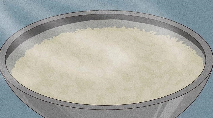 برنج گرم شده را در یک کاسه بزرگ بریزید و آن را با آب گر
